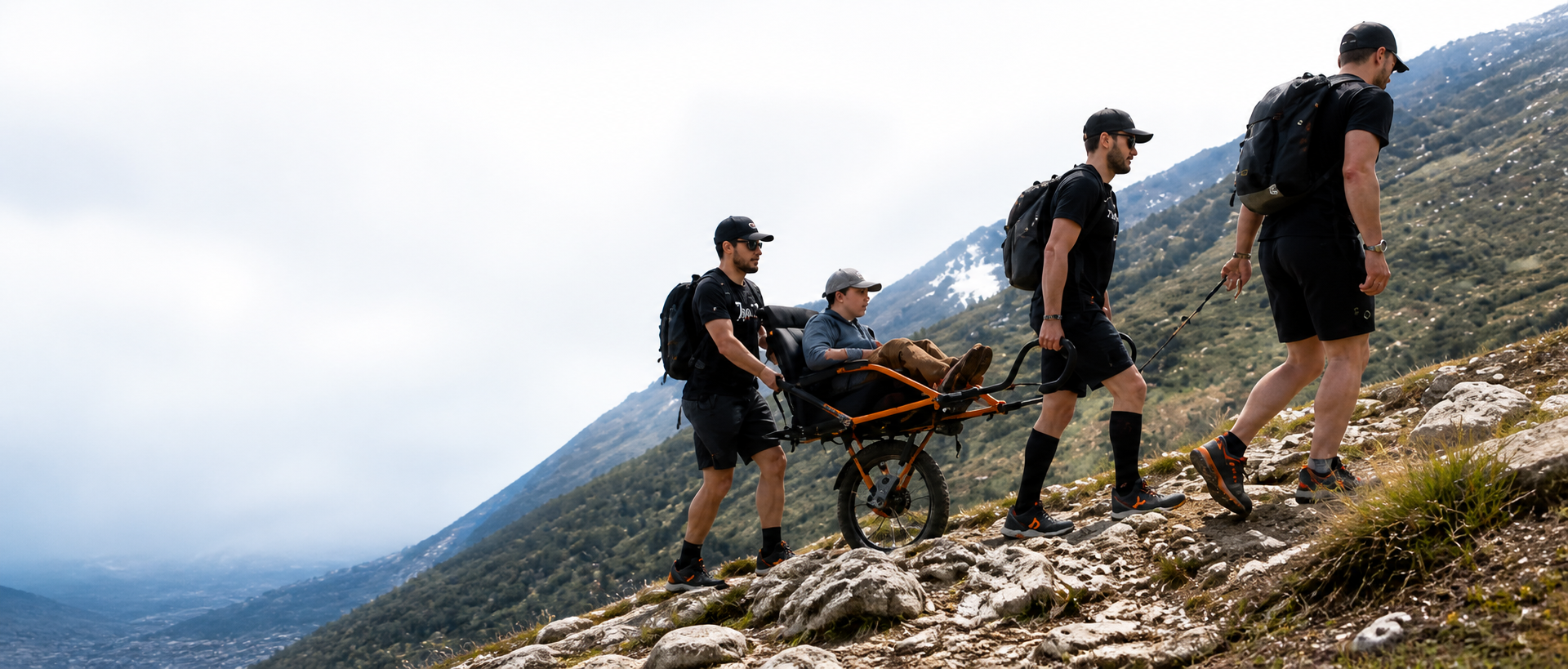 Equipo Yo Te Empujo llevando una joëlette por la montaña